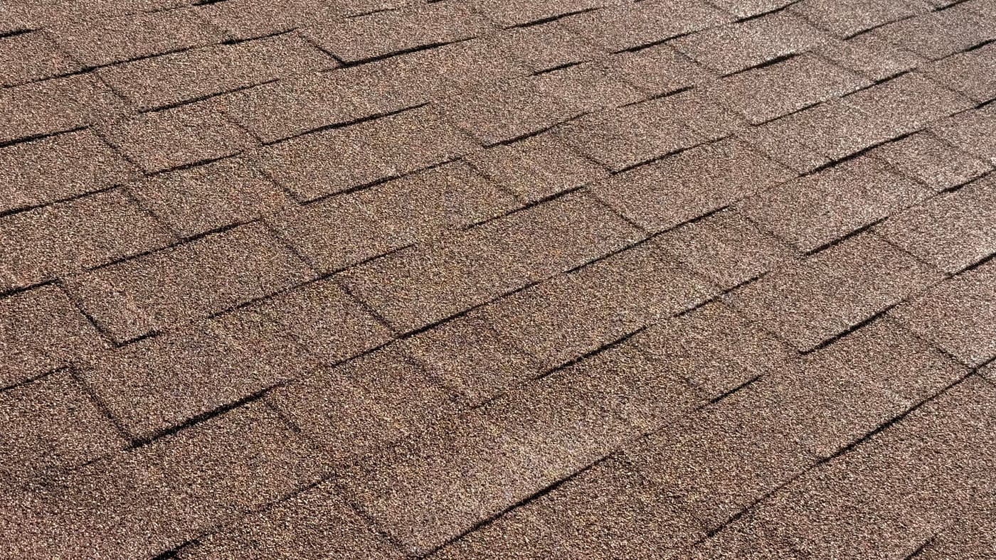Close-up of a coated residential roof surface with restored granular finish